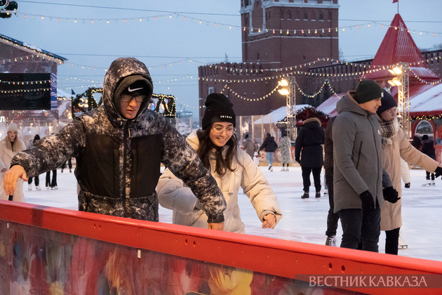 Люди катаются на ГУМ-катке на Красной площади